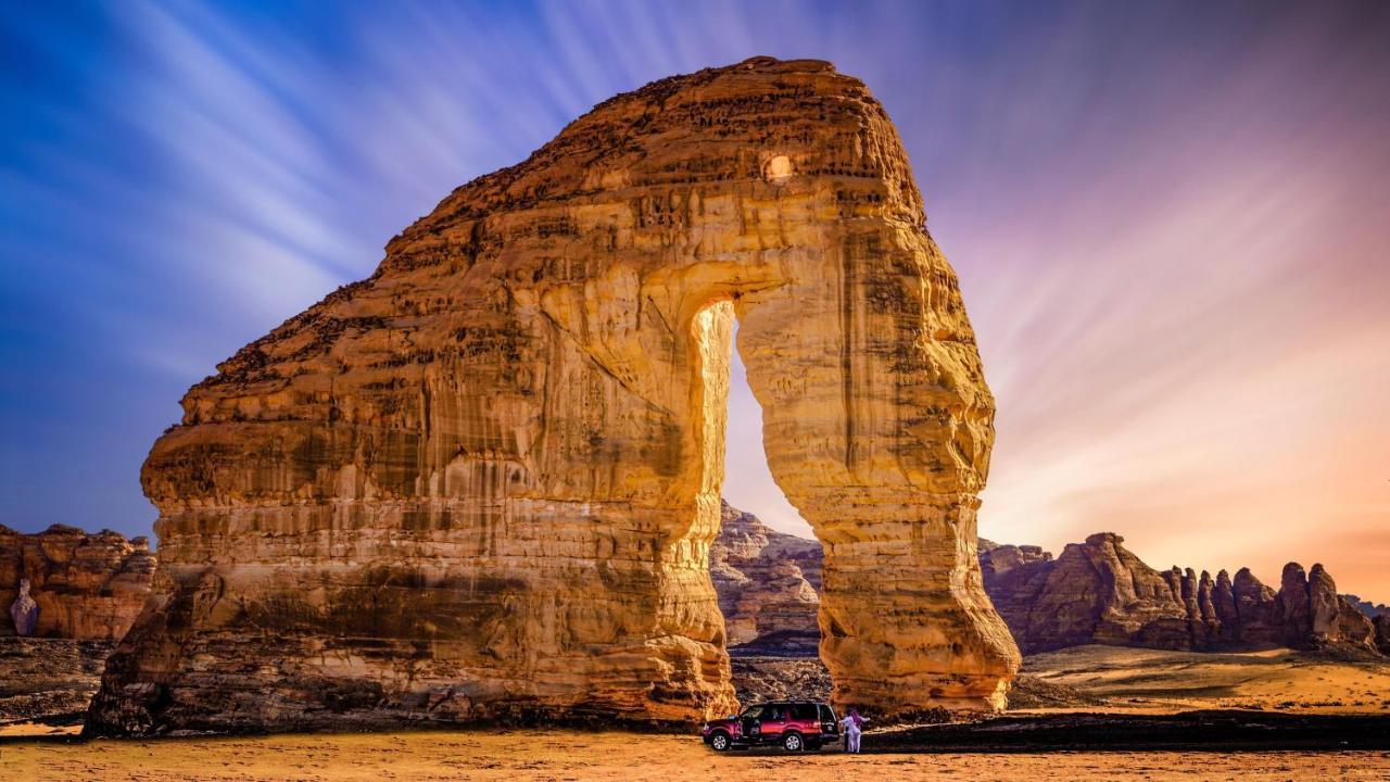 Intercontinental Dar Al Iman Madinah By Ihg Hotel Medina Ngoại thất bức ảnh The photo depicts a striking rock formation, characterized by a large archway that has been sculpted by natural processes. The landscape around the formation features sandy terrain and rugged terrain, typical of desert environments. In the foreground